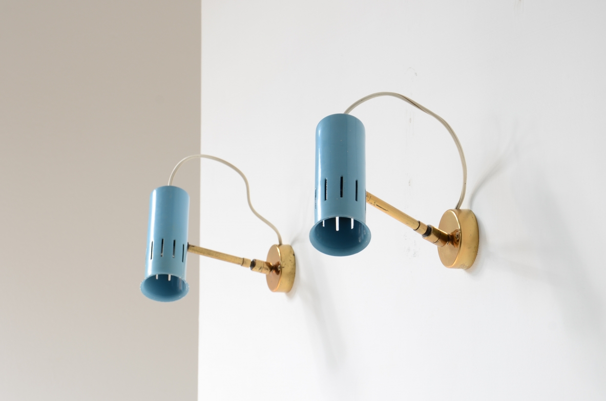 Pair of Italian adjustable wall lamps featuring light blue lacquered cylindrical metal shades with vertical ventilation slots, brass arms and circular wall mounts.