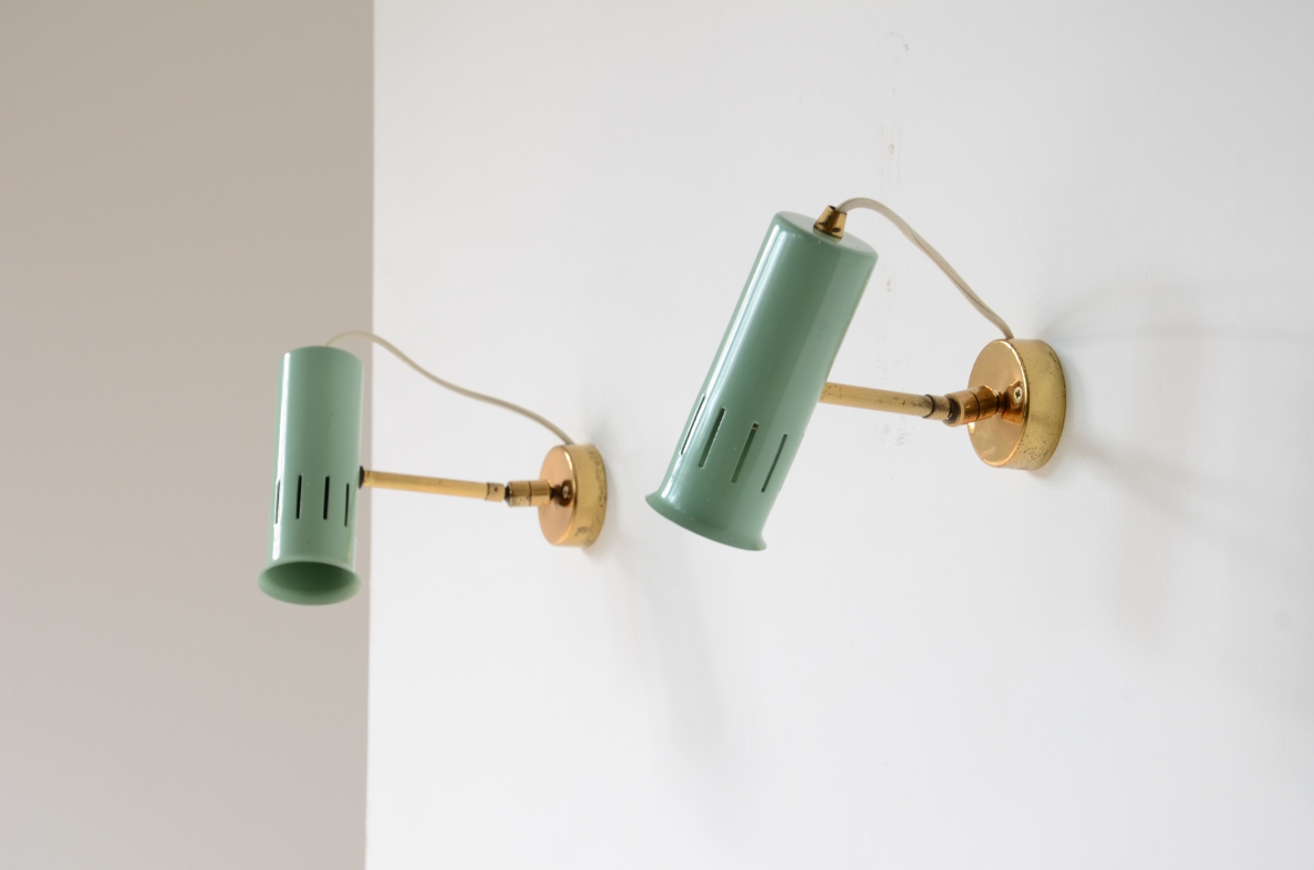 Pair of Italian adjustable wall lamps, featuring light green lacquered metal cylindrical shades, brass arms and circular wall mounts, photographed installed on a wall.