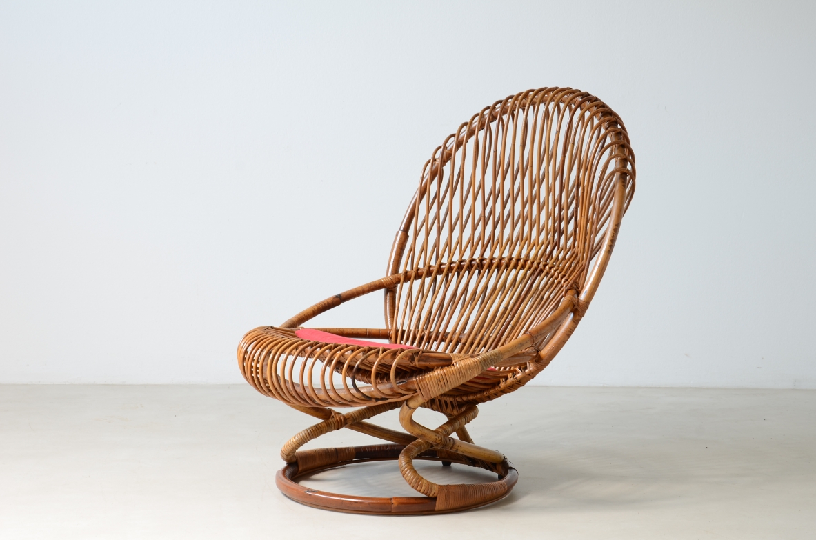 Vittorio Bonacina lounge chair, manufactured by F.lli Bonacina circa 1960, in woven rattan with tall curved backrest, rounded armrests, circular seat and ring-shaped base, photographed in three-quarter view.