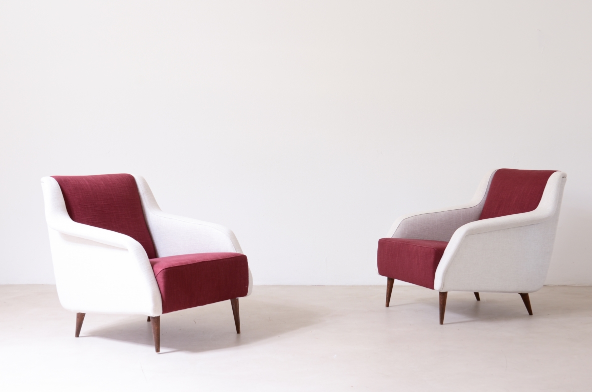 Pair of Carlo De Carli Model 802 armchairs by Cassina, with white upholstered frames, burgundy seats and backrests, curved armrests and slender angled legs.