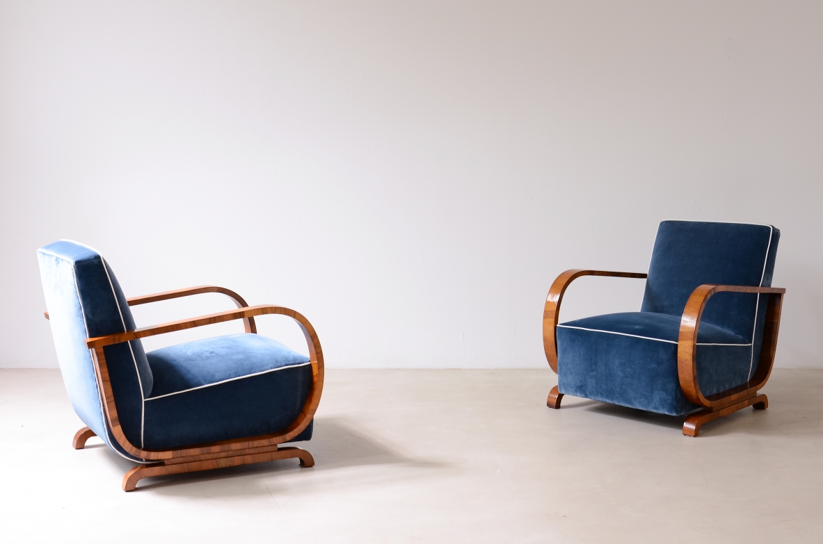 Pair of 1950s Hungarian armchairs with curved wooden armrests, blue velvet upholstery, rectangular backrests and shaped wooden bases.