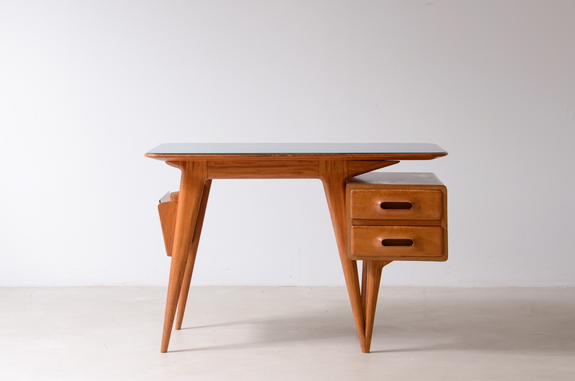 Italian writing desk by Silvio Cavatorta, manufactured by Cavatorta & Co. circa 1950, in blond wood with opaline glass top, two side drawers, magazine rack and tapered legs, front view.