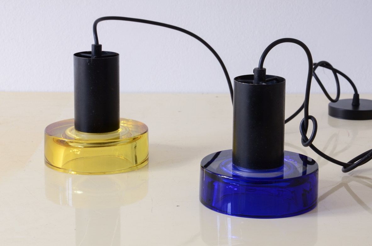 Pair of Flavio Poli lamps produced by Archimede Seguso circa 1960, featuring thick cylindrical uranium yellow and cobalt blue glass bases, black metal cylindrical bodies and electrical cords.