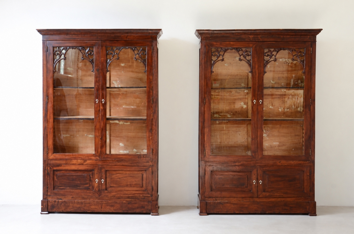 Pair of Neapolitan Charles X walnut glazed bookcases, circa 1830, with carved floral decorations, glass doors and original patina.